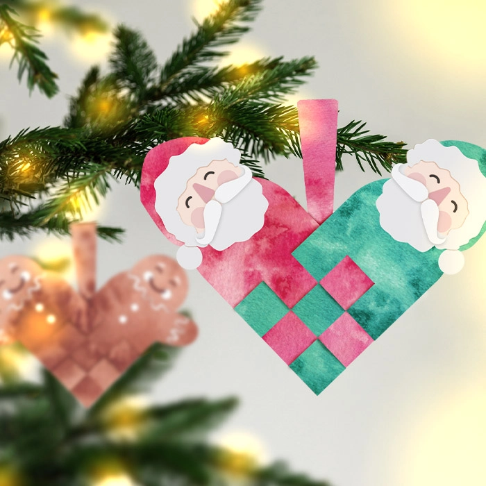 Flätade hjärtan i form av tomtar och pepparkakor hängandes på julgransgrenar