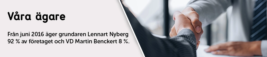 Två personer i kostym skakar hand över ett skrivbord, som symbol för affärsavtal eller samarbete.