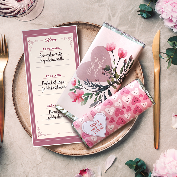 Lautanen, johon on aseteltu tulostettu illallismenyy ja kaksi suklaalevyä paperikääreellä.