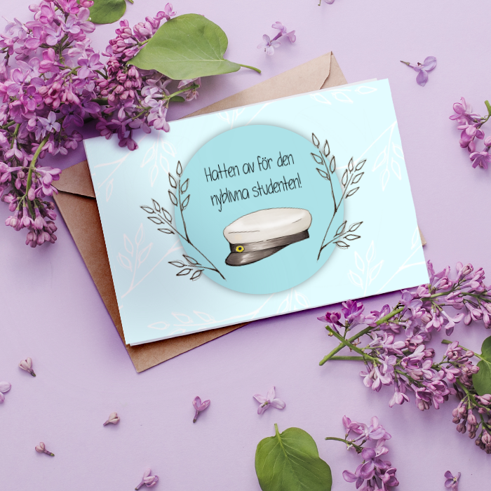Ett blått kort med en studentmössa och blad på en lila bakgrund med syrenblommor