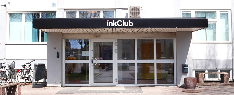 Entrée d’un bâtiment avec une enseigne au-dessus de la porte indiquant « inkClub ».