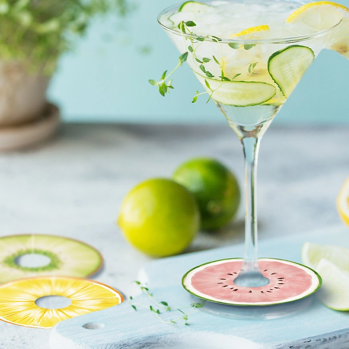 Glasmarkörer med fukktdesign på ett bord med ett drinkglas