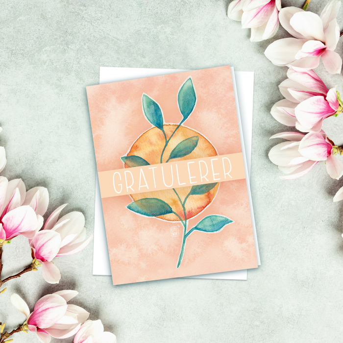Gratulasjonskort med blad og teksten Gratulerer, liggende på et bord med blomster.